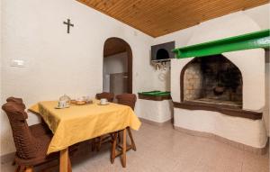 ein Esszimmer mit einem Tisch und einem Kamin in der Unterkunft 2 Bedroom Stunning Home In Susak in Susak