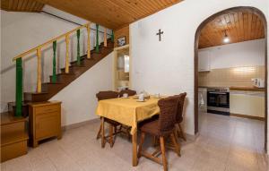 eine Küche und ein Esszimmer mit einem Tisch und einer Treppe in der Unterkunft 2 Bedroom Stunning Home In Susak in Susak