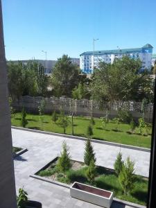 a view of a park with trees and a fence at Hotel KREZ in Qyzylorda