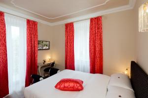 a bedroom with red curtains and a bed with a red pillow at Boutique Hotel Villa Sarnia in San Nazzaro