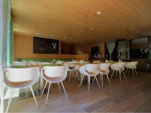 uma sala de jantar com cadeiras brancas e uma mesa em Aparthotel Alpinresort Damüls em Damüls