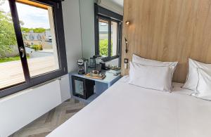 um quarto com uma grande cama branca e uma janela em Logis Hôtel du Parc em Perros-Guirec
