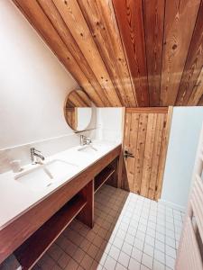 Łazienka z 2 umywalkami i drewnianym sufitem w obiekcie La Cabane, Superbe Duplex à 5 min des pistes w mieście Le Monêtier-les-Bains