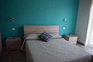 1 dormitorio con 1 cama con pared azul en Casa Ferrera - Locazione Turistica, en Misterbianco