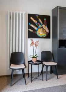 two chairs and a table in a room with a painting at B Home Apart Hotel by Alpha in Bogen