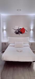 1 dormitorio con 1 cama blanca grande y una pintura en la pared en Loft Ciudad Jardín N°2, en Córdoba