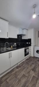 a kitchen with white cabinets and a sink and a stove at Ultra-Fine APARTMENTS in CENTRAL HALIFAX in Halifax