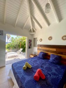 una camera da letto con un letto blu con due cuscini rossi sopra di Villa ACARIF a Sainte-Anne