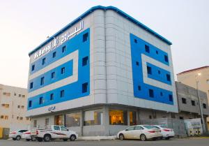 un edificio con auto parcheggiate di fronte di فندق البروج a Jazan