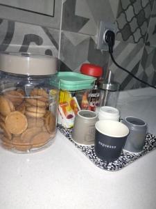 a jar of food sitting on a counter with cups at Lisbon, 3 bedroom apartment in Amora , 15 min from the beach in Amora