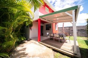 a house with a deck with a table and chairs at Domaine De Marly, 3 étoiles in Sainte-Anne