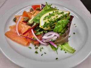 a white plate with a salad with fish and vegetables at Holly Tree Hotel, Swimming Pool & Hot Tub in Glencoe