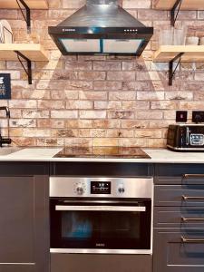 a kitchen with a stove top oven in a kitchen at Loft 11 Stunning LUXURY NYC Loft Style Interior Designed 2BD Apartment EXCELLENT CITY CENTRE LOCATION Mezzanine Cinema Room Designer Furniture AMAZING SPACE in Douglas