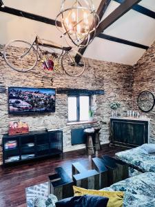 a living room with a bike hanging from a brick wall at Loft 11 Stunning LUXURY NYC Loft Style Interior Designed 2BD Apartment EXCELLENT CITY CENTRE LOCATION Mezzanine Cinema Room Designer Furniture AMAZING SPACE in Douglas