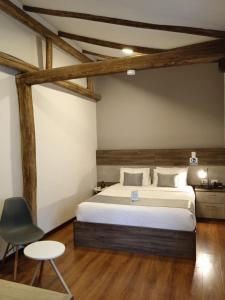 a bedroom with a large bed and a chair at Hotel Raymipampa in Cuenca
