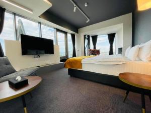 a hotel room with a large bed and a flat screen tv at WERK Hotel & SPA in Hunedoara