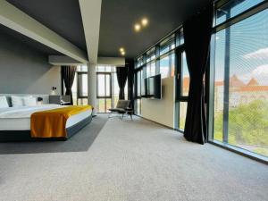a hotel room with a bed and large windows at WERK Hotel & SPA in Hunedoara