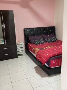 a bedroom with a black bed and a dresser at DinDas Family Stay @ Labuan in Labuan