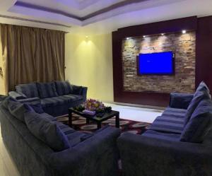 a living room with two couches and a tv at فندق البروج in Jazan