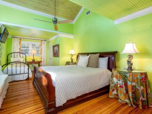 um quarto com uma cama e paredes verdes em Blue Skies em Tybee Island