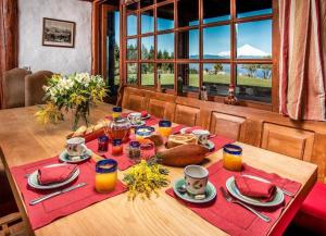 a dining room table with a table set with orange juice at Hill & Sky Lodge in Pucón