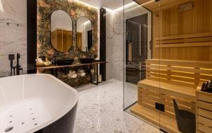 a bathroom with a tub and a sink and mirrors at One Luxury Suites in Belgrade