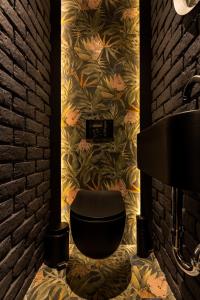 a bathroom with a black toilet and a brick wall at One Luxury Suites in Belgrade