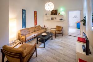 ein Wohnzimmer mit einem Sofa und Stühlen in der Unterkunft Mehringdamm in Berlin