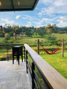 a piano on a deck with a view of a field at Acogedor y moderno Glamping en container, 10 min del centro in Chiquinquirá