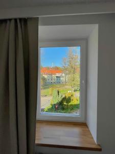 uma janela com vista para uma casa em Sosnowy Apartament em Polanica-Zdrój