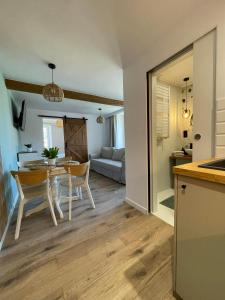 a kitchen and living room with a table and chairs at Sosnowy Apartament in Polanica-Zdrój