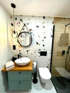 a bathroom with a sink and a toilet and a mirror at Sosnowy Apartament in Polanica-Zdrój