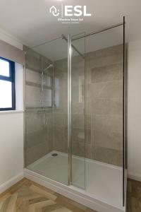 een douche met een glazen deur in de badkamer bij Comfy Modern 2 Bedroom Duplex Apartment with Sun Terrace in Shrewsbury
