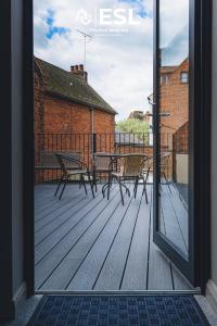 eine Terrasse mit Tischen und Stühlen auf einer Terrasse in der Unterkunft Comfy Modern 2 Bedroom Duplex Apartment with Sun Terrace in Shrewsbury