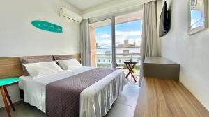 um quarto com uma cama e uma grande janela em Dona Floripa em Florianópolis