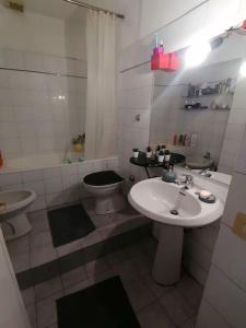 biała łazienka z umywalką i toaletą w obiekcie La Tua Casa A Trastevere w Rzymie