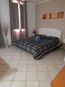 a bedroom with a bed with a plaid blanket at Civico 2 in Sassari