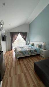 a bedroom with a bed and a large window at Cozy life ไออุ่น in Khao Kho