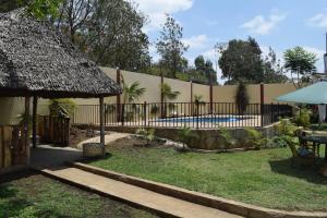 a backyard with a fence and a swimming pool at Stasumo House Arusha in Arusha