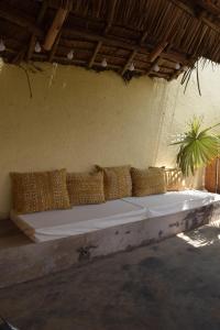 a large white bed with pillows on a wall at Stasumo House Arusha in Arusha