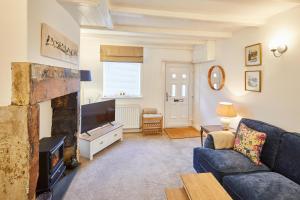 sala de estar con sofá y chimenea en Host & Stay - Waterlily Cottage, en Great Ayton