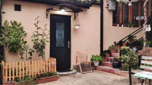 ein Haus mit schwarzer Tür und einigen Pflanzen in der Unterkunft Mia's Apartment in Tbilisi City