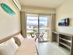 a living room with a couch and a sliding glass door at Dona Floripa in Florianópolis