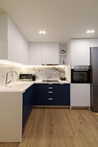 een keuken met blauwe en witte kasten en apparaten bij Blu & Marrone Suites-free parking in Thessaloniki