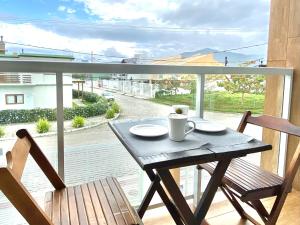 a table and chairs on a balcony with a view of a street at Dona Floripa in Florianópolis