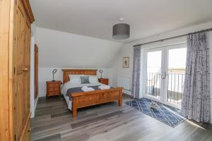 a bedroom with a bed and a large window at Driftwood, 29 Furzedown Road in Kingsbridge