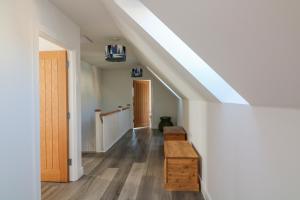 an attic hallway with a skylight and a wooden bench at Driftwood, 29 Furzedown Road in Kingsbridge