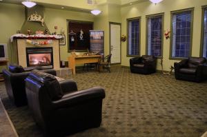 a waiting room with leather chairs and a fireplace at Nova Inn Inuvik in Inuvik
