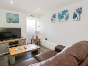 a living room with a couch and a television at Annabels Loft in Hawes