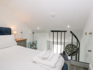 a bedroom with a white bed and a staircase at Annabels Loft in Hawes